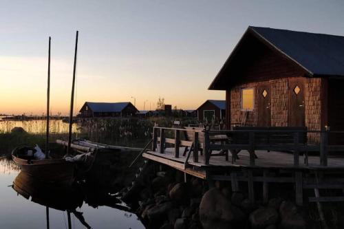 a dock with a bench and a boat on the water at Fisherman's cottage in Björköby