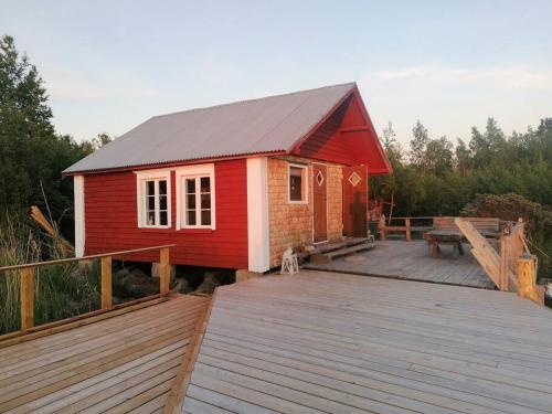 a small red house on a wooden deck at Fisherman's cottage in Björköby