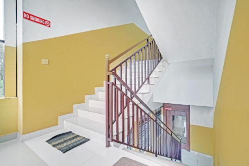 una escalera en una casa con una pared amarilla en OYO Flagship Thaza en Nedumbassery