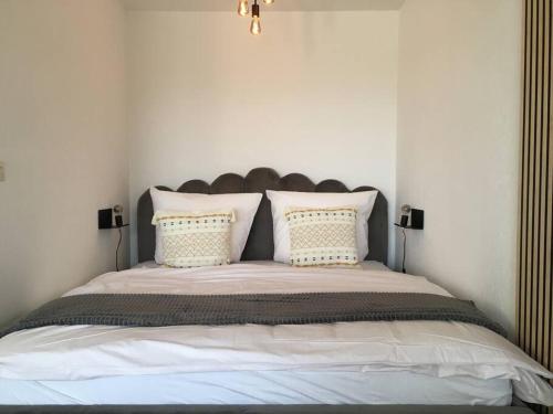 a bedroom with a large bed with white sheets and pillows at Gemütliches Apartment mit wundervollem Weitblick in Löffingen