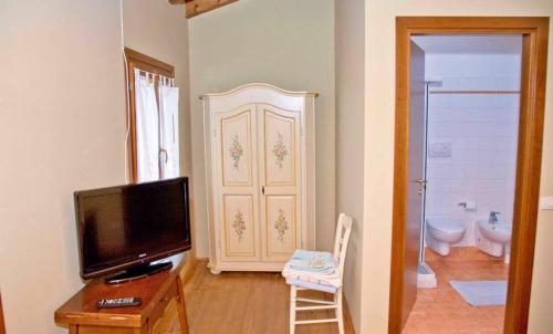 ein Wohnzimmer mit einem TV und einem Badezimmer in der Unterkunft Agriturismo Maliso in Ceggia