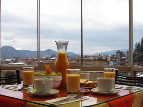 a table with a glass vase of orange juice at HOUSE MIRAFLORES in Cajamarca
