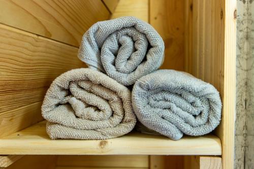 a pile of towels sitting on a wooden shelf at The Woolpack Glamping in Maidstone