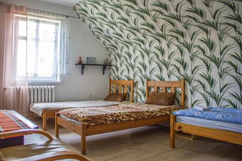 チェシンにあるDomek na Wzgórzuのベッド2台と壁画が備わる客室です。