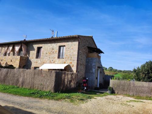 a stone house with a fence in front of it at Agriturismo Il Borgo della Canapa in San Benedetto