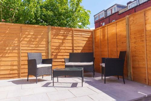 a patio with chairs and a table and a fence at Monroe House Leeds in Leeds