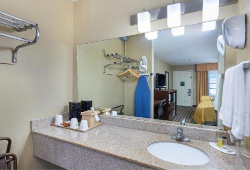 baño con lavabo y espejo grande en Super 8 by Wyndham Nashville West, en Nashville