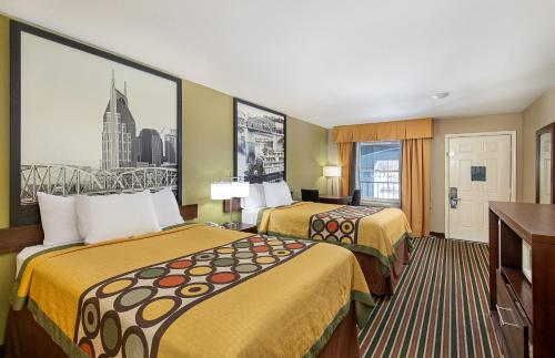 Habitación de hotel con 2 camas y ventana grande. en Super 8 by Wyndham Nashville West, en Nashville