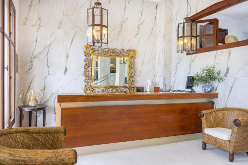 a dressing room with a mirror and a chair at Leandros Hotel in Nea Roda