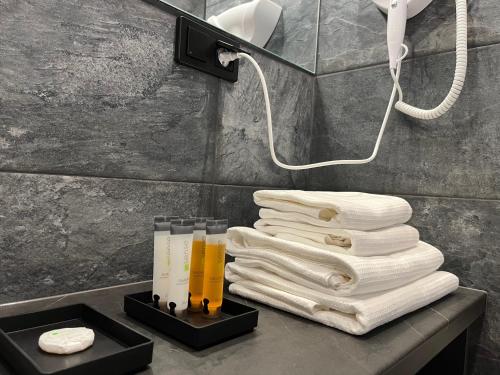 una pila de toallas en una encimera en el baño en Apartament Manhattan Premium - I-wsza Dzielnica - by Kairos Apartments en Katowice