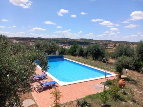 una piscina en un patio con sillas y árboles en Casa De Terena, en Terena