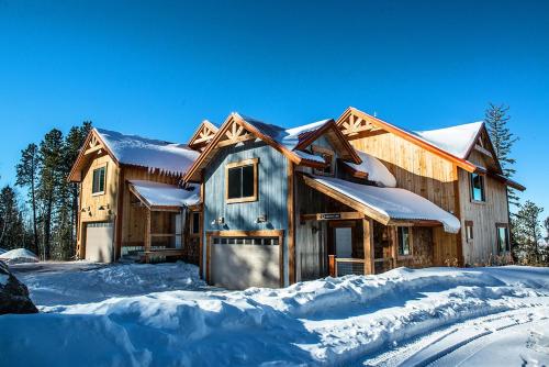 uma casa de madeira com neve no chão em Missing Link Chalet at Terry Peak em Lead