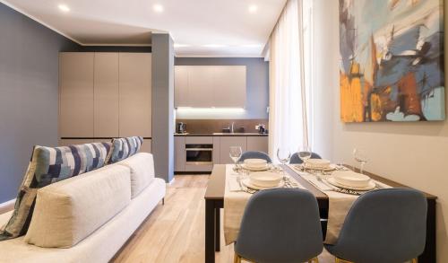 Blue Suite by Studio Vita في بولونيا: غرفة معيشة مع طاولة طعام وكراسي