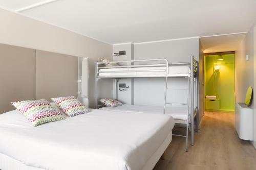 a bedroom with two beds and a bunk bed at Campanile Dole in Dole