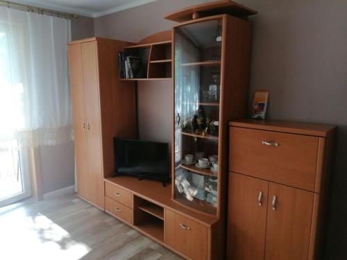 a large wooden cabinet with a television in a room at Apartament przy puszczy in Hajnówka