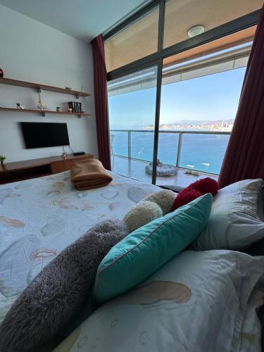 a bedroom with a bed with a view of the ocean at Apartamento Paraiso Lido in Benidorm