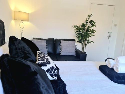 a living room with a bed and a couch at immaculate 3-Bedrooms Dundee Apartment in Dundee