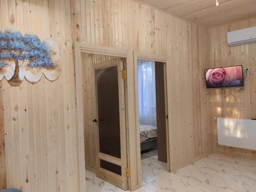 a room with wooden walls and a room with a bedroom at Коттедж у моря in Batumi