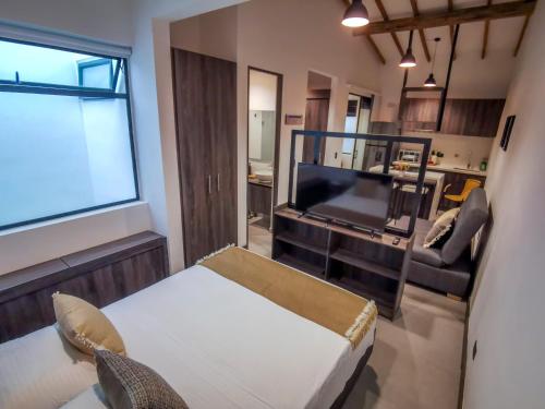 a living room with a bed and a tv and a couch at Casa García Rent Home in Guatapé