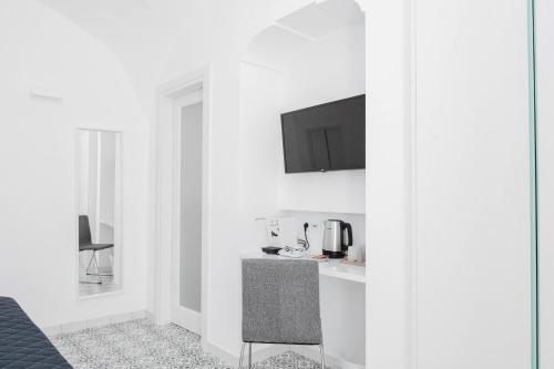 uma cozinha com paredes brancas e um balcão e uma cadeira em Na Stanza in centro em Ravello