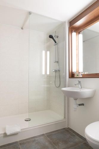 a bathroom with a shower and a sink at Campanile Dole in Dole