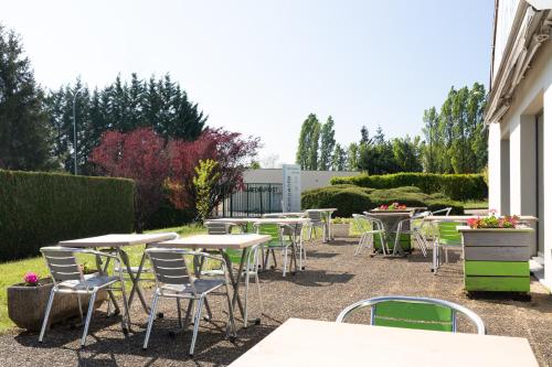 a row of tables and chairs in a garden at Campanile Dole in Dole