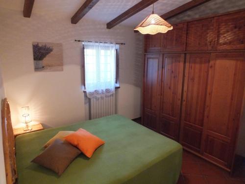 a bedroom with a green bed and a window at Trulli La Ghianda in Noci