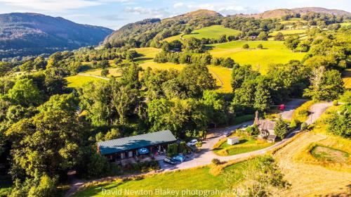 an aerial view of a farm house in the hills at MotoCamp Wales -Camping Pods in Dolgellau