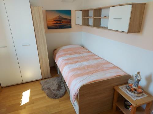 a small bedroom with a bed and a table at Villa M & D in Sveti Filip i Jakov