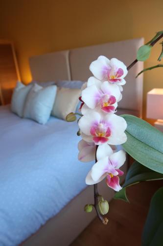 a bunch of white flowers next to a bed at Bourne House, private modern apartment near Rugby & Lutterworth 