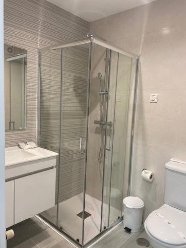 a bathroom with a shower and a toilet and a sink at Hotel Ancora Mar in Nazaré