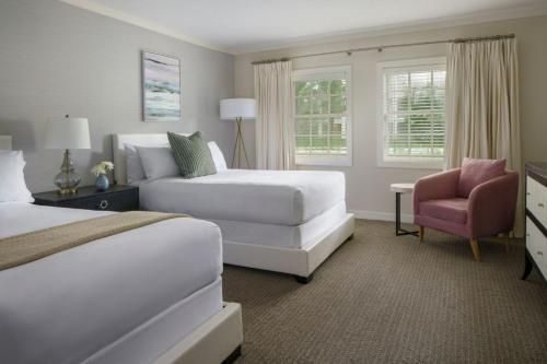 a hotel room with two beds and a chair at Bungalows at The Boca Raton in Boca Raton