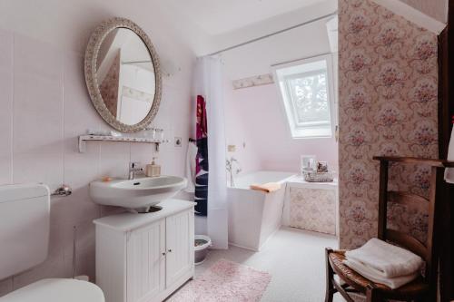 Baño blanco con lavabo y espejo en Olifant in Osterode, en Osterode