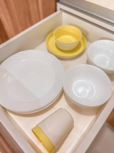 four white plates and bowls on a tray at [Starry x DELUX] 8-10pax *free Netflix access in Masai