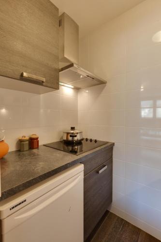 une cuisine avec un évier et un plan de travail dans l'établissement Appartements avec balcon vue sur la montagne - Serre Chevalier Chantemerle, à Saint-Chaffrey