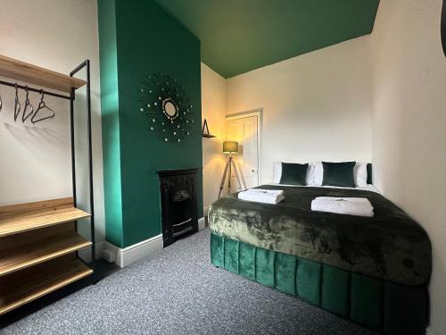 een slaapkamer met een bed en een groene muur bij Westwood Place in Spon End