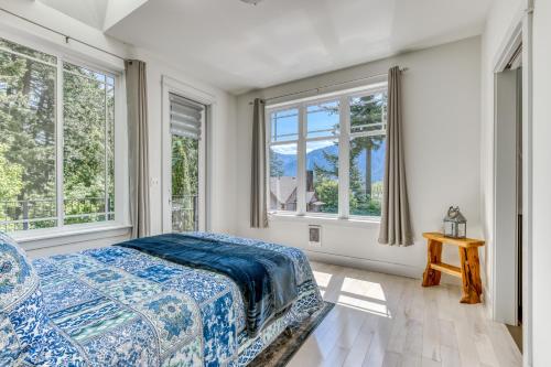1 dormitorio con ventanas, 1 cama y 1 mesa en River Gorge Elegance, en Stevenson