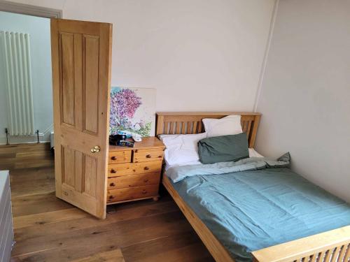 a bedroom with a bed and a wooden dresser at Hoylake 2 double bedrooms, continental breakfast included for the 151ist golf open at the Royal Liverpool in Hoylake