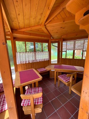 an inside view of a cabin with tables and benches at Ferienwohnungen LODGE-B in Weissenbach am Lech