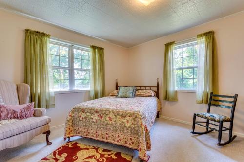 Schlafzimmer mit einem Bett, einem Stuhl und Fenstern in der Unterkunft Delaware Vacation Rental Walk to Lake Dardanelle! 