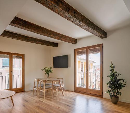 a dining room with a table and chairs and windows at El Jardinillo del Salvador in Cuenca