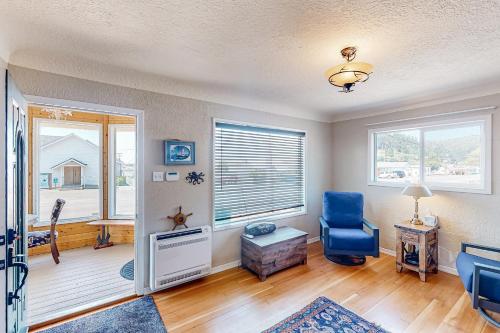 sala de estar con silla azul y ventana en Cozy Corner by the Bay, en Reedsport