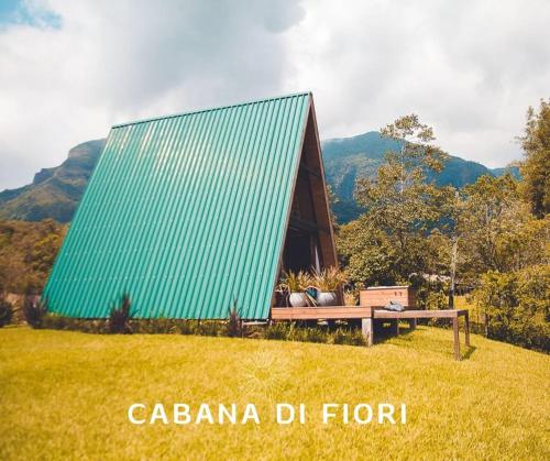 a green roofed house with a bench in a field at Vilaggio Bengazi in Treviso