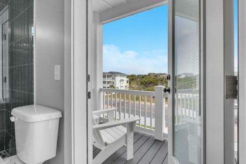 a bathroom with a toilet and a balcony with a view at Weekend Rescue in Oak Island