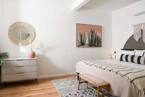 a bedroom with a bed and a mirror and a dresser at 1 Bedroom Casita - Casa Blanca in Montecito