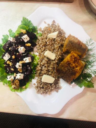 a plate of food with meat and vegetables on a table at Катерина in Chynadiyovo