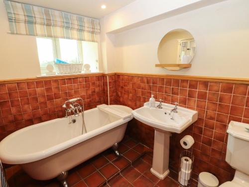 a bathroom with a tub and a sink at White House in Penrith