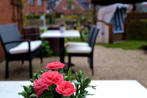 a vase with pink flowers sitting on a table at Haus Ohio Garni in Borkum