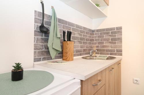 a kitchen with a sink and a brick wall at Apartma Mimi in Izola