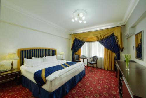 モスクワにあるモスクワ ホリデイ ホテルの大きなベッドとデスクが備わるホテルルームです。
